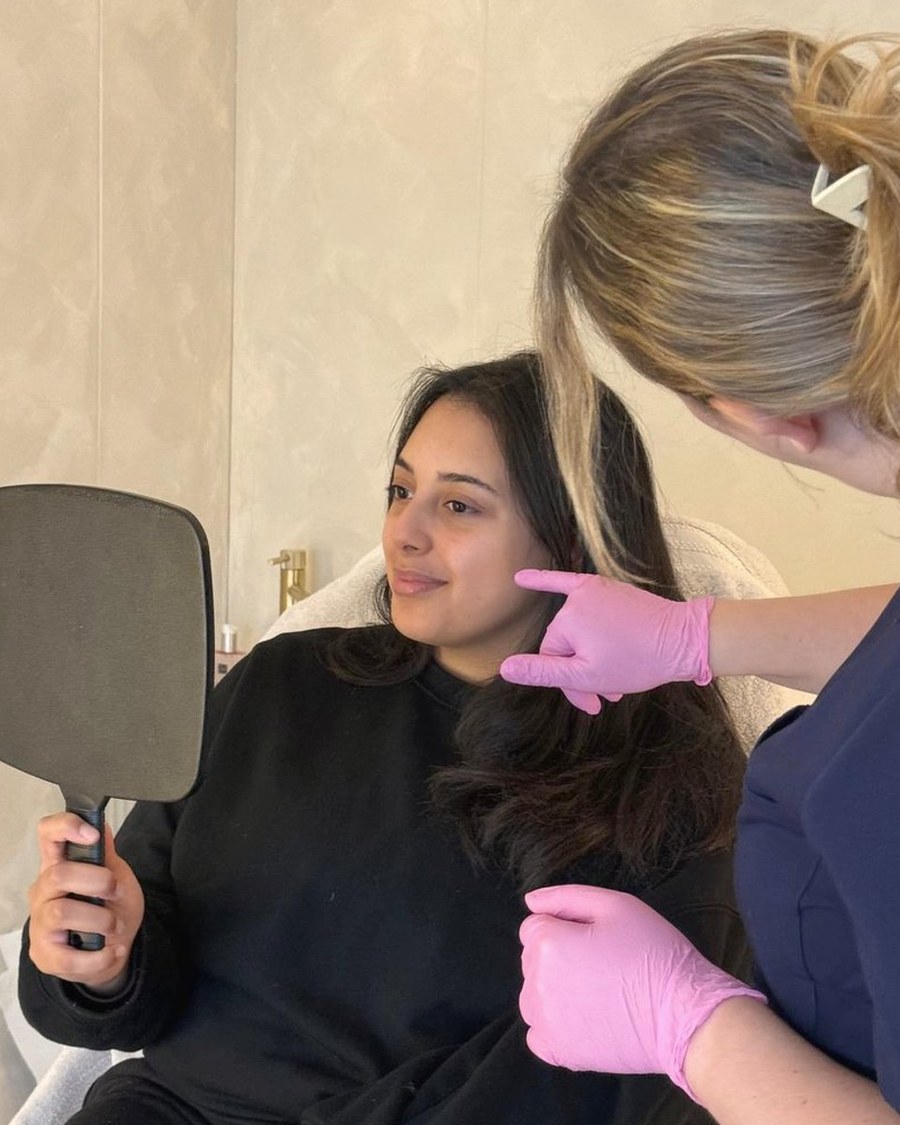 Rachel talking a client through her treatment with a hand mirror