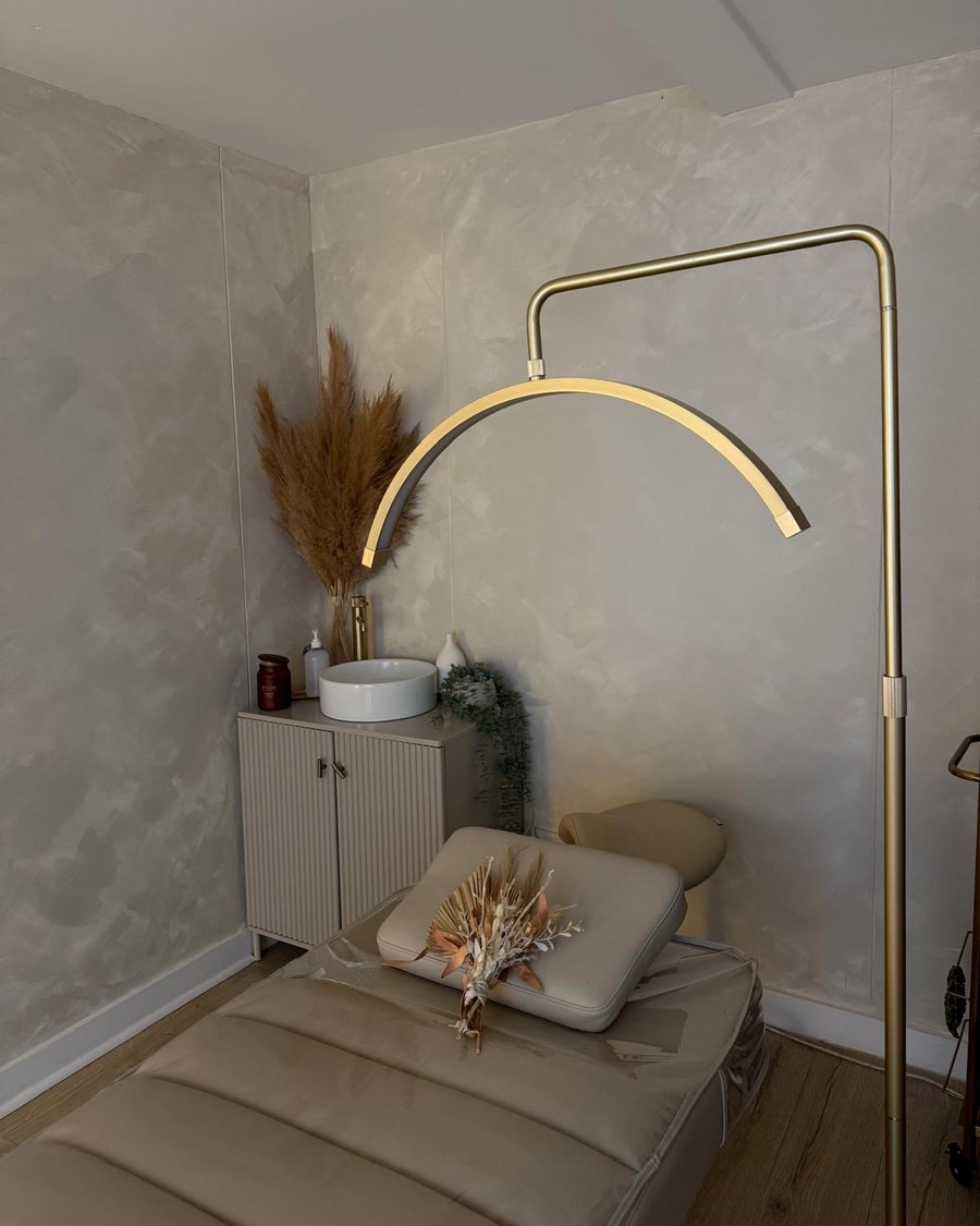 Maya treatment room with a gold arched lamp, treatment bed and basin