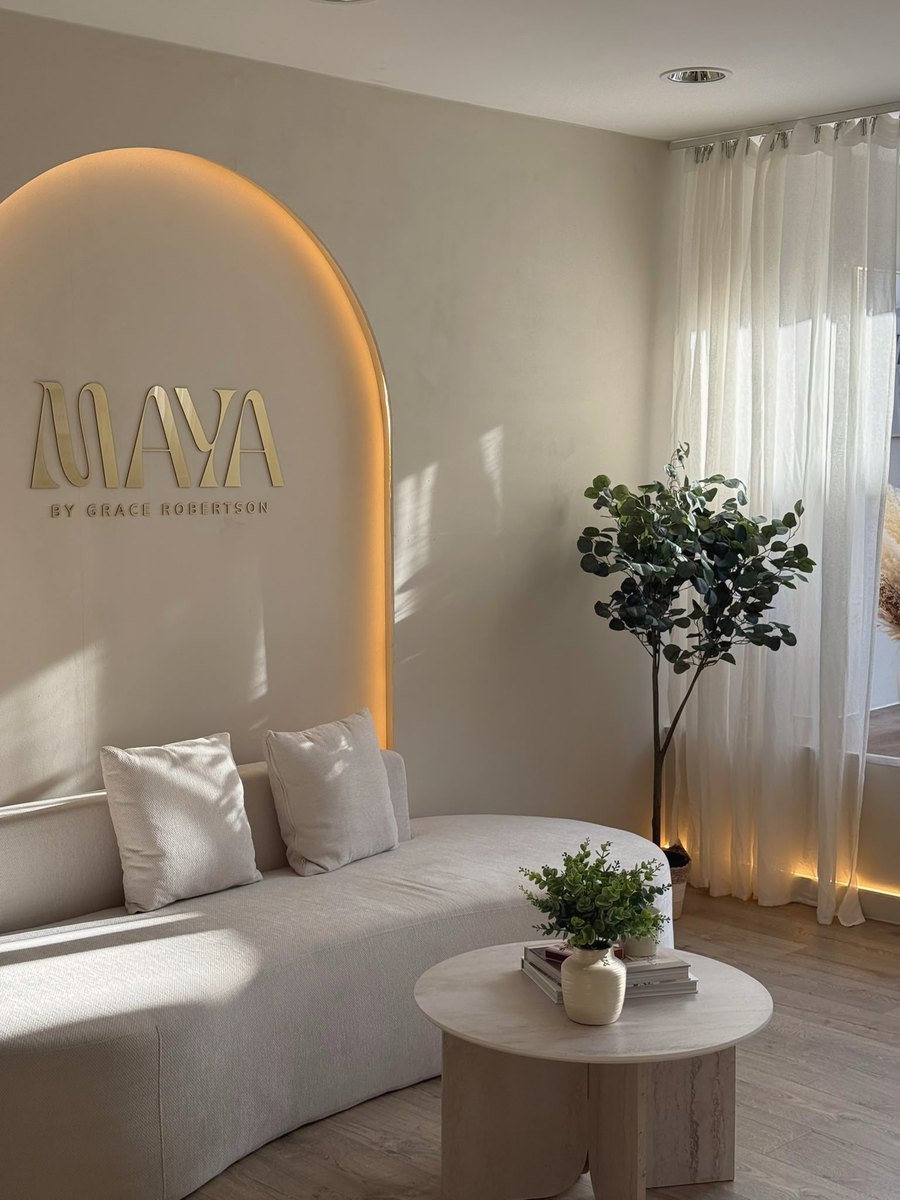 Maya reception with illuminated arched MAYA sign and cream sofa