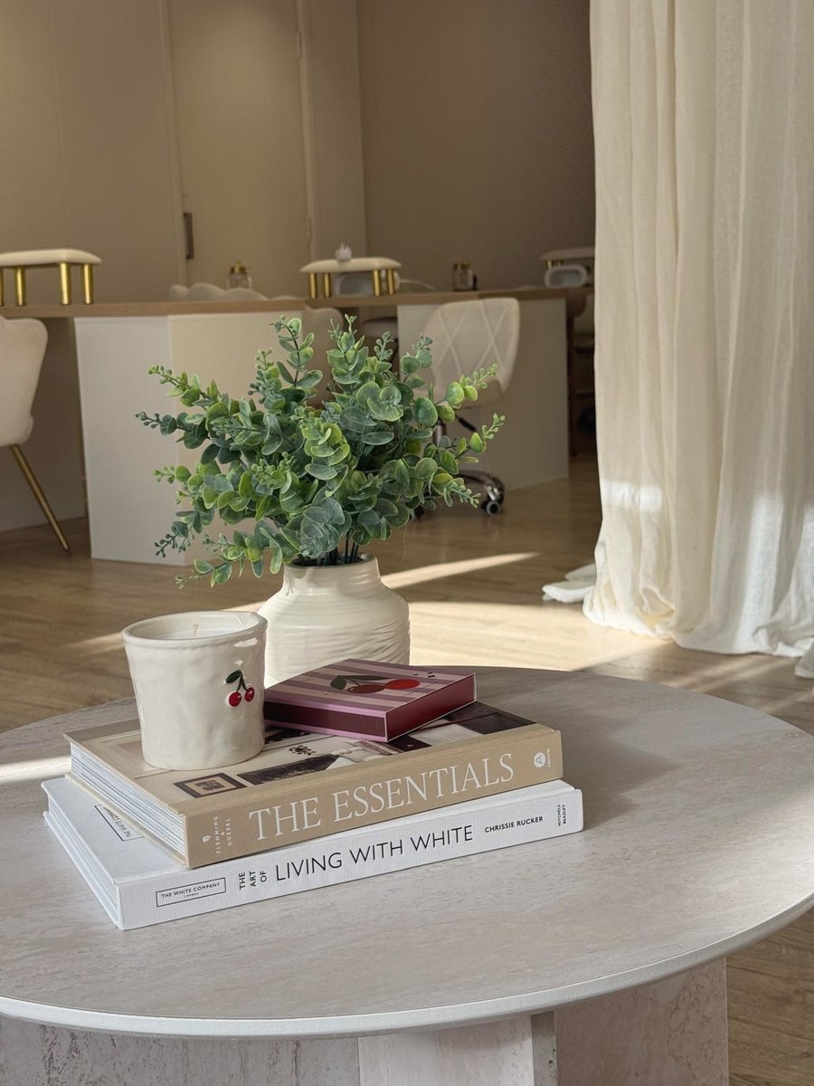Maya reception coffee table with books, candle and eucalyptus, nail desks behind