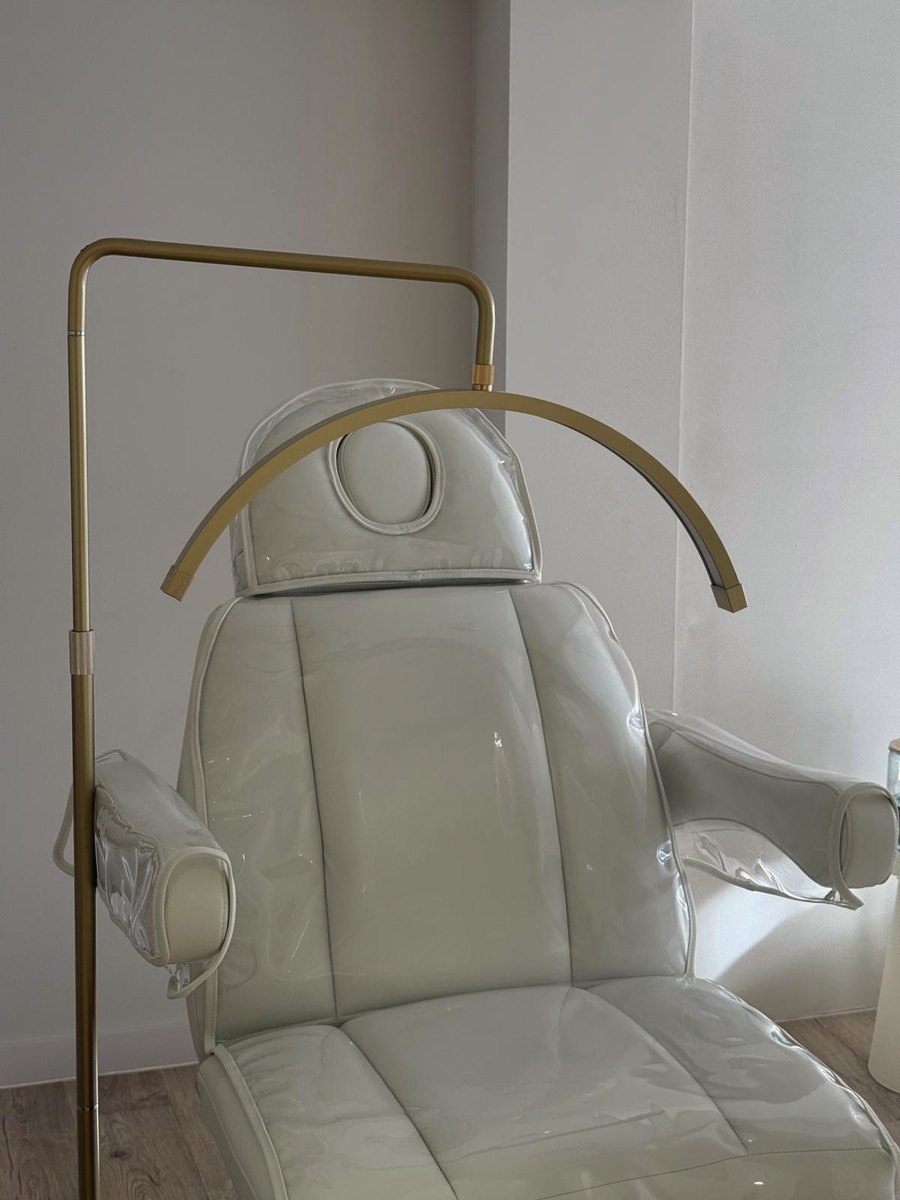 Maya white treatment chair with gold arc lamp